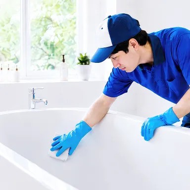 浴槽を手作業で磨くクリーニングスタッフ